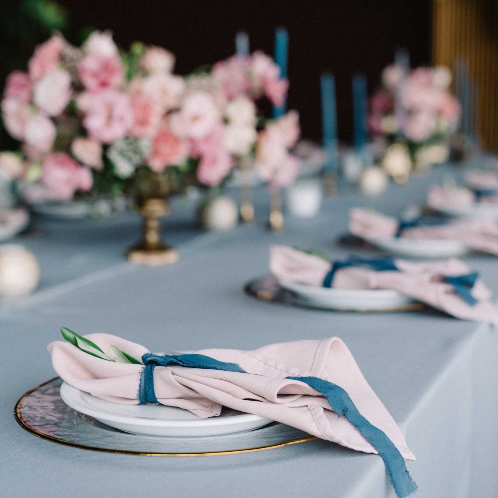 Stylish and beautiful wedding table service with blue tablecloth, festive dishes and gentle pink napkins chicago baby shower venue inexpensive